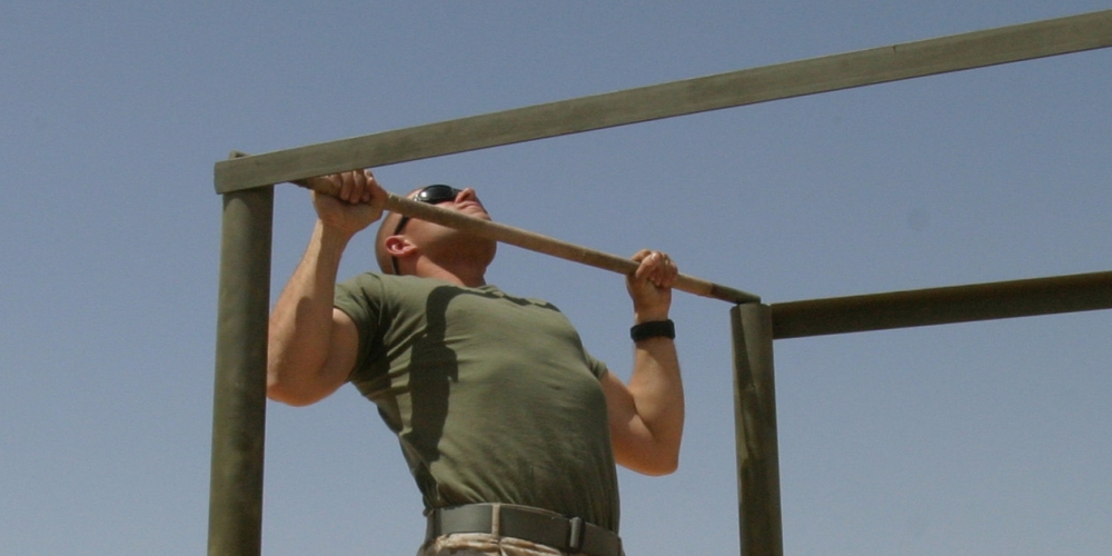 CAMP TAQADDUM, Iraq -- A rifleman with the Provisional Rifle Company, Headquarters and Service Battalion, 2d Force Service Support Group (Forward), Lance Cpl. Jacob T. Barker does pull-ups as part of his daily physical training program. The San Antonio native's job while deployed to Iraq, fighting the Global War on Terrorism, is to provide security for the service members aboard the base.